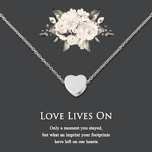 Puede incluir: Un collar de plata con un colgante de coraz&oacute;n y un dise&ntilde;o floral. El collar tiene una cita que dice: "LOVE LIVES ON Only a moment you stayed, but what an imprint your footprints have left on our hearts."