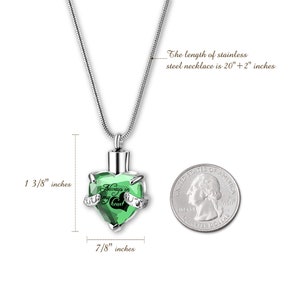 May include: A silver necklace with a green crystal heart pendant. The pendant is 1 3/8 inches tall and 7/8 inches wide. The necklace is 20 inches long with a 2 inch extender. The pendant has the words "Always in my heart" inscribed on it.