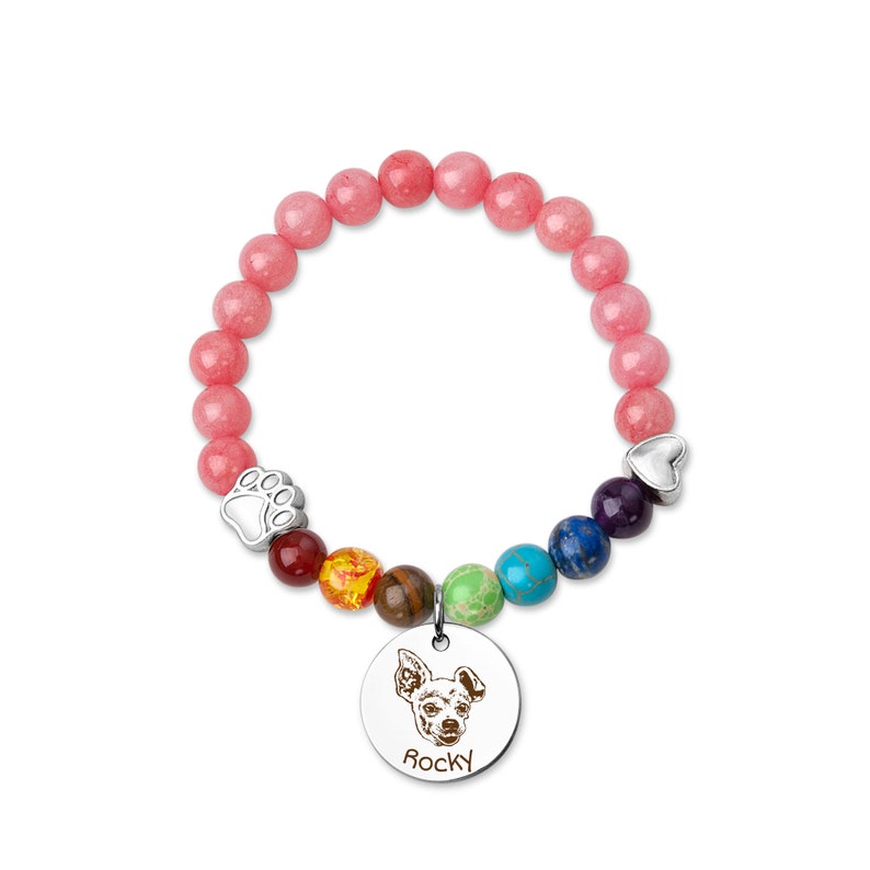 May include: A pink beaded bracelet with a silver paw print charm, a rainbow of colored beads, and a silver charm with a dog's face and the name "Rocky" engraved on it.