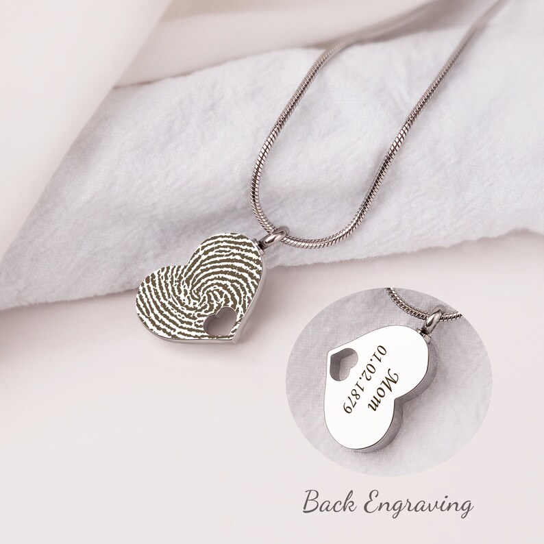 Puede incluir: Collar de plata en forma de coraz&oacute;n con un dise&ntilde;o de huella digital en la parte delantera y una inscripci&oacute;n en la parte posterior que dice "Mam&aacute; 6.28.17.0.10".