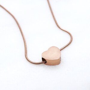 Puede incluir: Un collar de cadena de oro rosa con un colgante en forma de coraz&oacute;n.