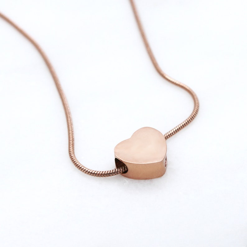 Puede incluir: Un collar de cadena de oro rosa con un colgante en forma de coraz&oacute;n.