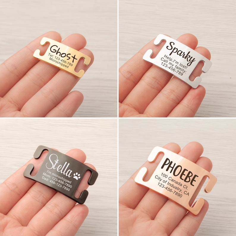 May include: Four different dog collar ID tags with engraved text. The tags are made of metal and have a gold, silver, black, and rose gold finish. The text on the tags includes the dog's name, phone number, and microchip information.