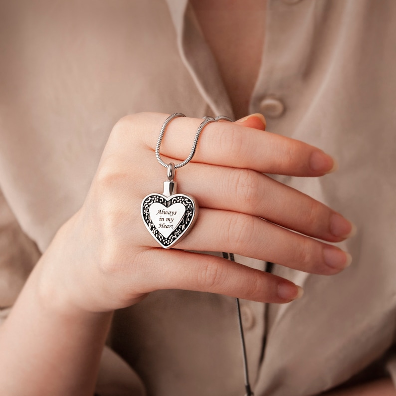 Puede incluir: Collar de cremaci&oacute;n de coraz&oacute;n plateado con una cadena delicada. El colgante tiene una inscripci&oacute;n grabada que dice "Always in my Heart".