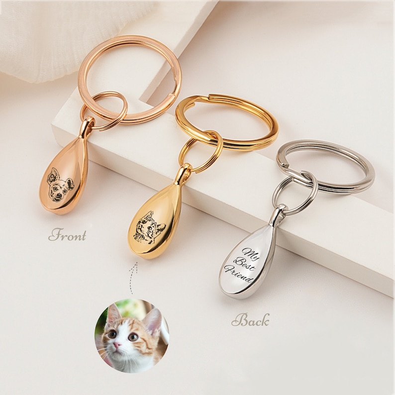 Peut inclure: Trois porte-cl&eacute;s avec des breloques en forme de larme. Les breloques sont grav&eacute;es avec le portrait d'un animal de compagnie sur le devant et les mots "Mon meilleur ami" au dos. Les porte-cl&eacute;s sont disponibles en or, argent et or rose.