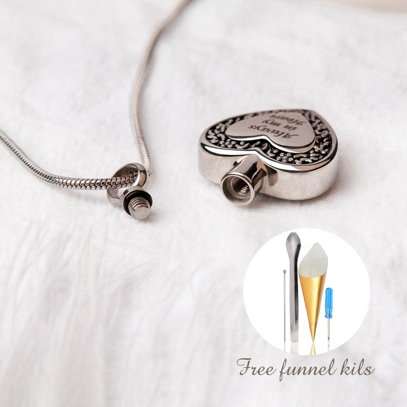 Puede incluir: Collar de cremaci&oacute;n de coraz&oacute;n plateado con una cadena. El colgante tiene una inscripci&oacute;n que dice "Siempre en mi coraz&oacute;n". El collar viene con un kit de embudo para llenar el colgante.