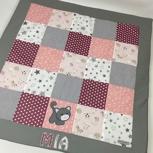 Könnte beinhalten: Eine graue und rosafarbene Patchwork-Spielmatte mit einem grauen Rand und einer Katzenapplikation. Die Spielmatte hat einen weißen Hintergrund mit rosa und grauen Sternen und einem rosa und weißen Bauernhoftier-Druck. Die Spielmatte ist mit dem Namen "MIA" in grauen Buchstaben personalisiert.