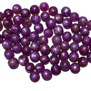 Può includere: Una collana di perle di rubino stellare viola. Le perle sono rotonde e hanno un motivo a forma di stella al centro.