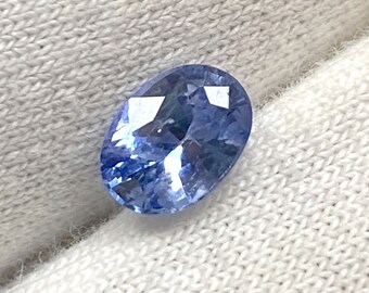 Puede incluir: Una piedra preciosa de zafiro de forma ovalada de color azul claro.