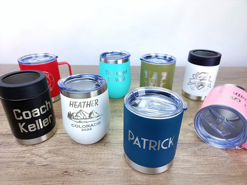 Puede incluir: Surtido de vasos de acero inoxidable personalizados con varios colores y dise&ntilde;os. Los vasos presentan nombres y frases grabados, incluyendo "Coach Keller", "Heather", "This might be wine", "Patrick" y "Austin Way".