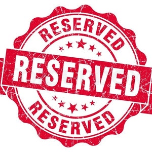 May include: Red and white distressed round stamp with the word "RESERVED" in a banner across the middle and the word "RESERVED" around the edge.
