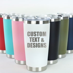 May include: A row of eight stainless steel tumblers with various colored exteriors. The tumbler in the center is white with the text "CUSTOM TEXT & DESIGNS" printed on it.