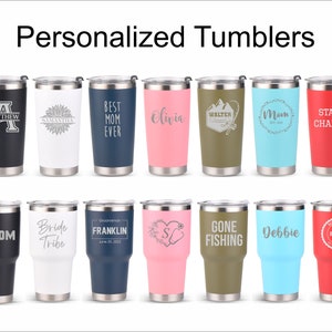 Puede incluir: Una colecci&oacute;n de vasos personalizados en varios colores, cada uno con base y tapa de acero inoxidable. Los vasos presentan texto y dise&ntilde;os personalizados, incluyendo nombres, frases y gr&aacute;ficos.