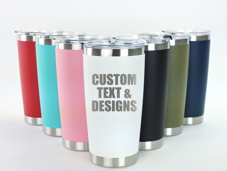 May include: A set of eight stainless steel tumblers in various colors, including red, blue, green, pink, and white. The white tumbler has the text "CUSTOM TEXT & DESIGNS" engraved on it.