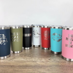 May include: Eight stainless steel tumblers with various colors and personalized engravings. The engravings include "Jefferson", "Best Dad Ever", "Hubby", "Elizabeth", "Captain Ray Wade", "Andrea", and "This Might Be Vodka".