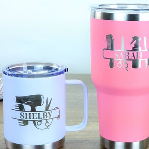 Puede incluir: Dos tazas de viaje de acero inoxidable con nombres personalizados y herramientas de peluquer&iacute;a. La taza m&aacute;s grande es rosa y dice "SARAH" y la taza m&aacute;s peque&ntilde;a es blanca y dice "SHELBY".