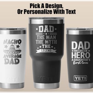 Pode incluir: Tr&ecirc;s canecas isoladas com bordas prateadas. Uma &eacute; branca com o texto "NACHO AVERAGE DAD" e um gr&aacute;fico de chap&eacute;u. A segunda &eacute; preta com o texto "DAD THE MAN THE MYTH THE LEGEND". A terceira &eacute; preta com o texto "DAD A SON'S FIRST HERO A DAUGHTER'S first love".