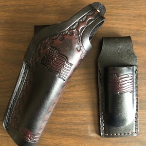 Puede incluir: Dos fundas de cuero negro con un dise&ntilde;o de bandera estadounidense. La funda m&aacute;s grande tiene un borde decorativo, mientras que la funda m&aacute;s peque&ntilde;a tiene un dise&ntilde;o sencillo.