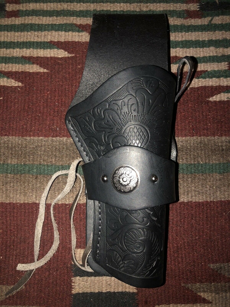 Peut inclure: Un &eacute;tui en cuir noir avec un motif floral et un bouton en m&eacute;tal argent&eacute;. L'&eacute;tui est dot&eacute; d'une sangle et d'une boucle pour l'attacher &agrave; une ceinture.