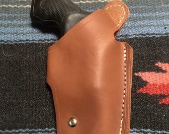 Funda de cuero de cuatro posiciones, de extracción cruzada, parte baja de la espalda, lado fuerte. Compatible con Smith & Wesson modelo 36, 37, 637 y Taurus modelo 85, 685.