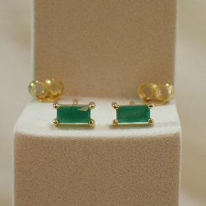Peut inclure: Une paire de boucles d'oreilles en or avec des pierres rectangulaires vert émeraude.