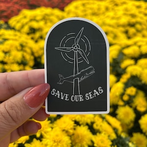 May include: Black and white sticker with a wind turbine and a whale, with the text "SAVE OUR SEAS".