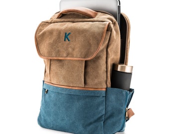 May include: A brown and blue canvas backpack with a leather handle and a zippered pocket on the side. The backpack has a laptop compartment and a water bottle holder. The backpack is monogrammed with the letter "K".