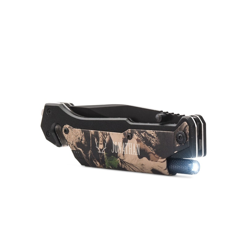 May include: A black and camouflage folding knife with a built-in flashlight. The knife has a personalized inscription that reads "JONATHAN".