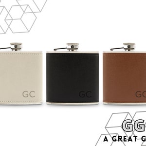 May include: Three hip flasks with leather coverings in white, black, and brown. Each flask has a silver top and the initials "GC" engraved on the front.