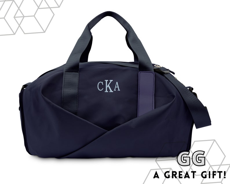 May include: A navy blue duffel bag with a zipper closure and a top handle. The bag has a gray embroidered monogram that reads 'CKA' and a purple leather strap on the front. Men's Personalized Gym Bag. Duffle Bag for Men. Gym Bag for Man. Gift for Him. Unique Gift for Dad. Father's Day Gift. Dad Gift.