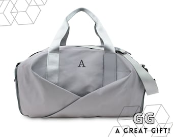 May include: A grey duffel bag with a white strap and a single letter "A" embroidered on the front. The bag has a zipped closure and a shoulder strap.