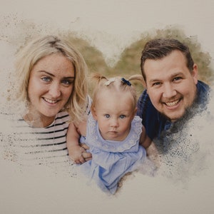 May include: A watercolor painting of a family with a mother, father, and a young child. The family is smiling and looking at the camera. The painting is in a heart shape.