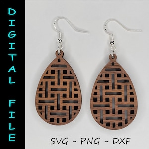 Puede incluir: Un par de pendientes de madera con un patrón geométrico. Los pendientes son marrones y tienen forma de lágrima. Los pendientes están hechos de madera y tienen un gancho plateado.