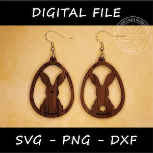 May include: A pair of wooden earrings shaped like an egg with a bunny silhouette inside. The earrings are brown and have gold hooks.