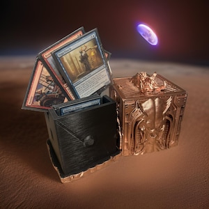 May include: A black and gold 3D printed card game deck box with a dragon design. The box is open and has a stack of Magic: The Gathering cards inside. The cards include "Naga Oracle", "Spirits of the Magus", "Bomber", and "Mulldrifter".