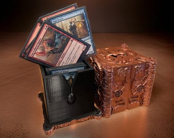 May include: A black and copper card storage box with a deck of Magic: The Gathering cards inside. The cards include "Naga Oracle", "Sun-Crowned Raptor", and "Sphinx of Magosi".