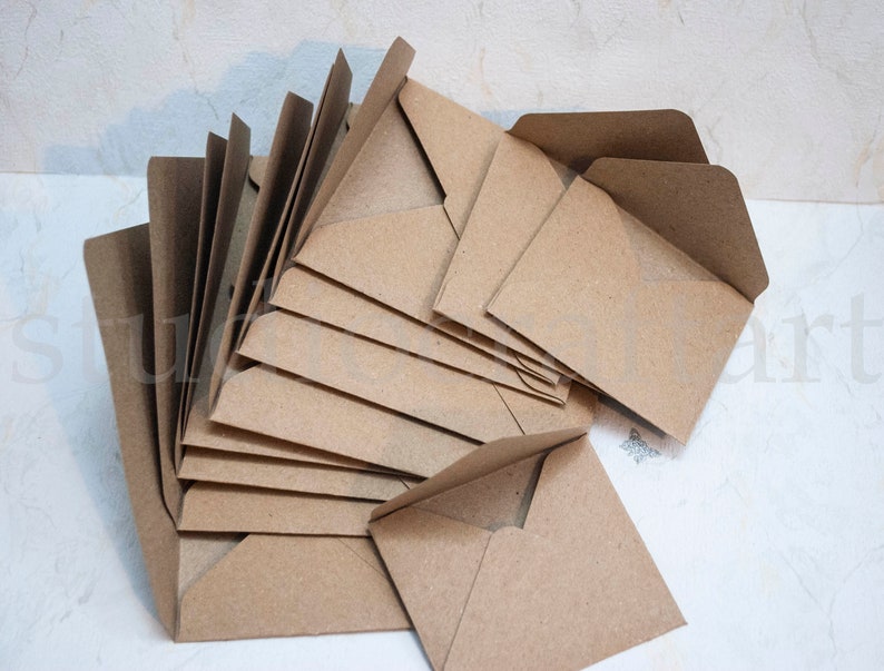 K&ouml;nnte beinhalten: Ein Stapel brauner Kraftpapierumschl&auml;ge. Die Umschl&auml;ge sind gefaltet und bereit zum Versenden von Briefen oder Karten.