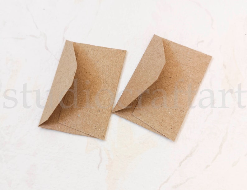May include: Two brown paper envelopes, folded and ready for use. The envelopes are made of a textured paper and have a natural, rustic look.