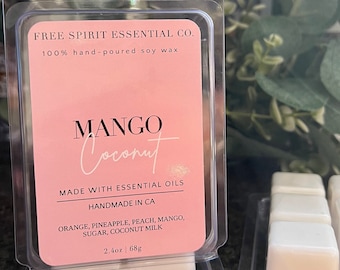 May include: A pink and white label with the text "FREE SPIRIT ESSENTIAL CO. 100% hand-poured soy wax MANGO Coconut MADE WITH ESSENTIAL OILS HANDMADE IN CA ORANGE, PINEAPPLE, PEACH, MANGO, SUGAR, COCONUT MILK 2.4oz | 68g" on a clear plastic container with a white wax melt inside. The wax melt is divided into six squares.