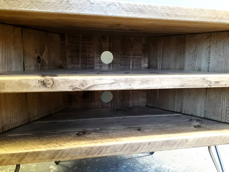 K&ouml;nnte beinhalten: Ein Eck-TV-St&auml;nder aus Holz mit zwei Ablagen und einer abgenutzten Oberfl&auml;che. Der St&auml;nder hat zwei runde L&ouml;cher auf der R&uuml;ckseite f&uuml;r die Kabelverwaltung.