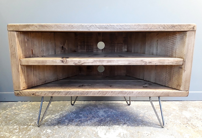 K&ouml;nnte beinhalten: Ein Eck-TV-St&auml;nder aus recyceltem Holz mit zwei Regalen und Haarnadelbeinen. Der St&auml;nder hat zwei L&ouml;cher auf der R&uuml;ckseite f&uuml;r Kabel.