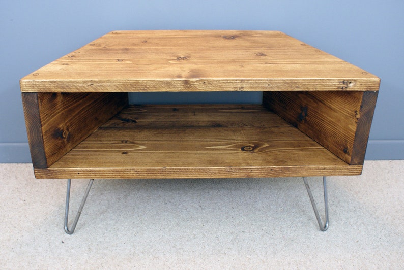Peut inclure: Table basse en bois rustique avec un plateau rectangulaire et une &eacute;tag&egrave;re ouverte. La table est teint&eacute;e d'une couleur marron chaud et poss&egrave;de des pieds en &eacute;pingle &agrave; cheveux en m&eacute;tal. Mesure environ 76 cm de long, 46 cm de large et 41 cm de haut.