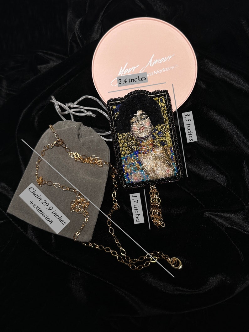 May include: A beaded necklace with a black and gold pendant featuring a portrait of a woman. The pendant is 1.7 inches tall and 3.5 inches wide. The chain is 29.9 inches long with an extension. The necklace comes in a pink box with the text "Your Amour" and "na Mankevych".