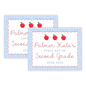 May include: Two blue and white gingham patterned signs with red scalloped borders. The top sign says "Palmer's Last Day of Second Grade 2022-2023" with three red apples. The bottom sign says "Palmer Kate's First Day of Second Grade 2022-2023" with three red apples.