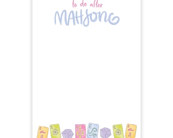 May include: A white notepad with the text "to do after MAH JONG" in pink and blue script. The bottom of the notepad features colorful Mahjong tiles and dice.