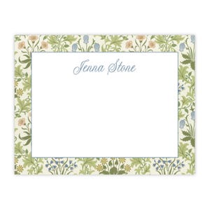 May include: A white card with a floral border in shades of green, blue, and pink. The text "Jenna Stone" is printed in blue cursive script in the center of the card.