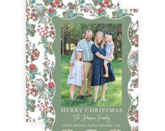 May include: A rectangular holiday card featuring a white background with a colorful floral paisley pattern. A central sage green scalloped frame displays a family photo and the text MERRY CHRISTMAS, The Johnson Family, william, katherine, charlotte and evelyn • 2025.