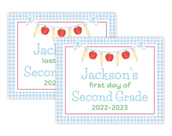 May include: Two blue and white gingham patterned signs with red borders. The top sign says "Jackson's last day of Second Grade 2022-2023". The bottom sign says "Jackson's first day of Second Grade 2022-2023". Both signs have a string of red apples and yellow pencils.