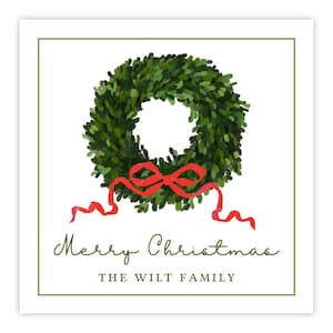 May include: A square greeting card featuring a painted green wreath with a bright red ribbon bow at the bottom. Below the wreath, the text reads Merry Christmas in a green script font, followed by THE WILT FAMILY in a simple green serif font.