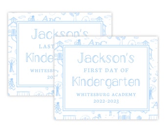 May include: Two blue and white signs with a schoolhouse theme. The top sign says "Jackson's Last Day of Kindergarten Whitesburg Academy 201..." The bottom sign says "Jackson's First Day of Kindergarten Whitesburg Academy 2022-2023".